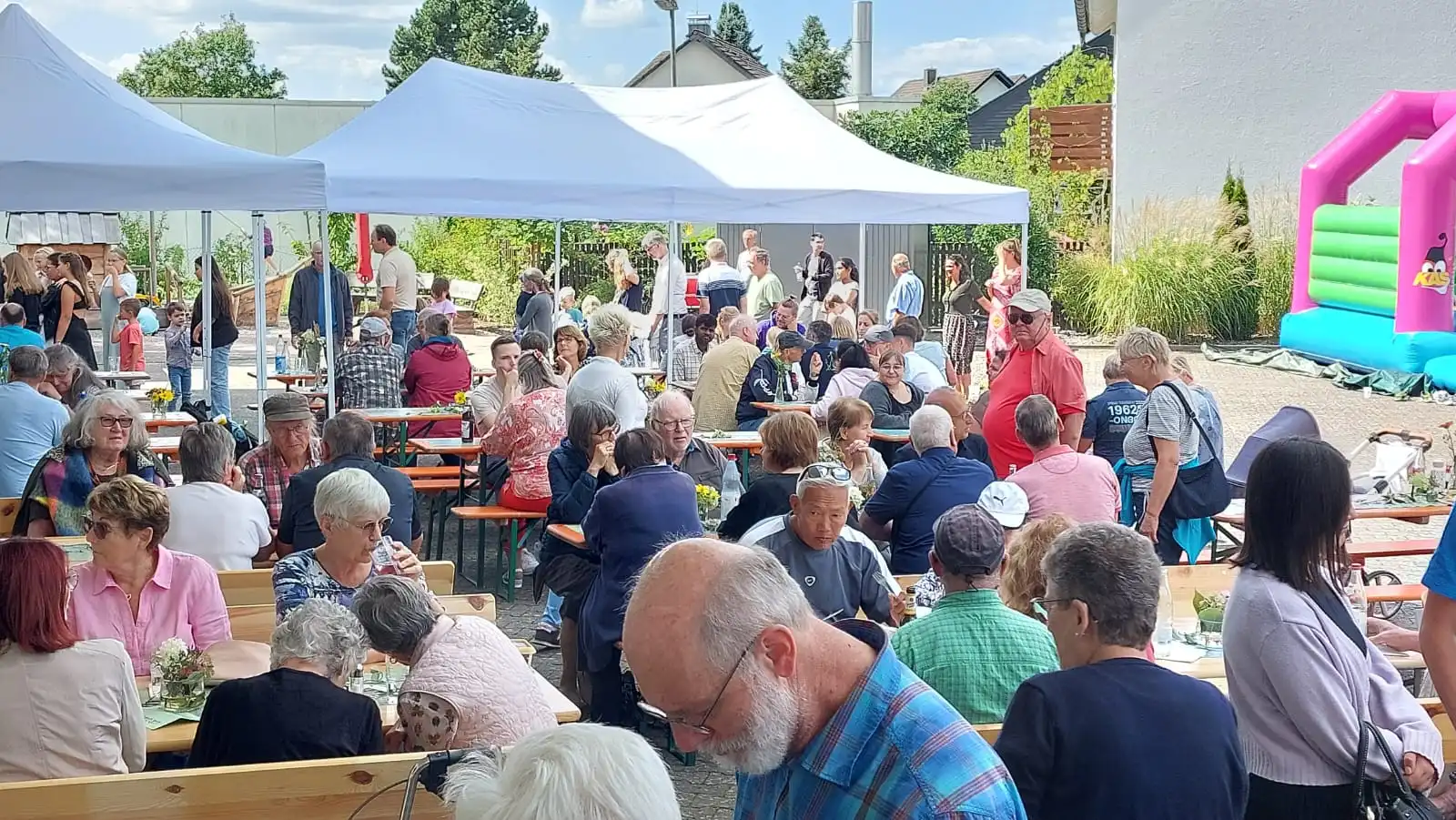 Leute entspannt an den Tischen im Hof