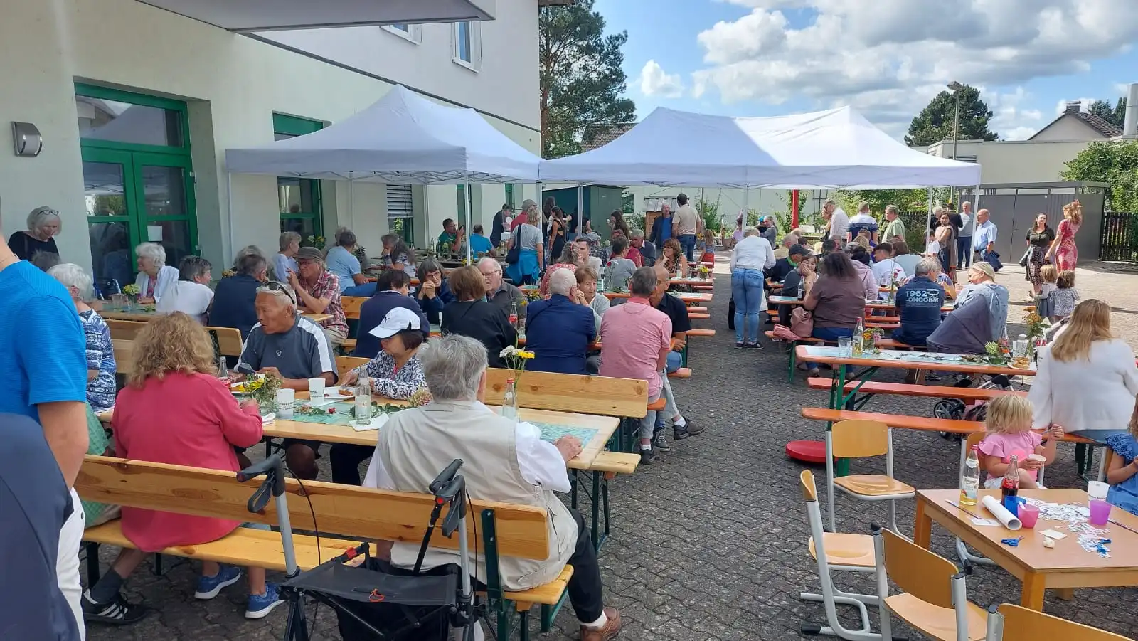 Leute entspannt an den Tischen im Hof